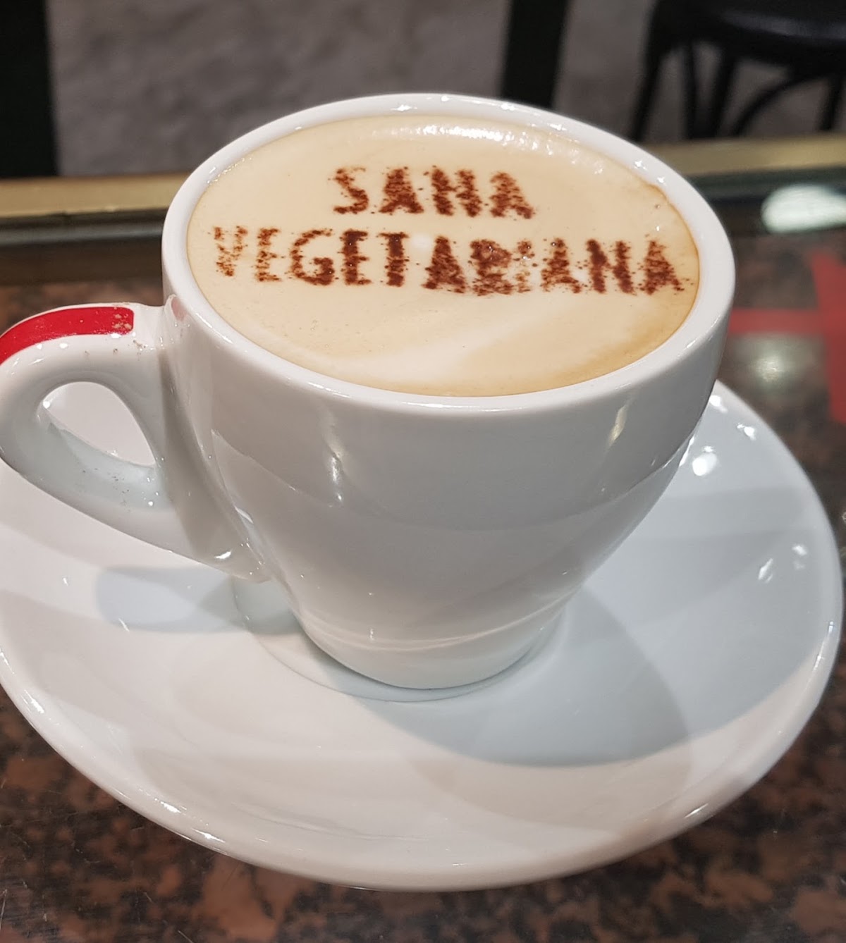 Café con el nombre de Sana Vegetariana en el arte latte